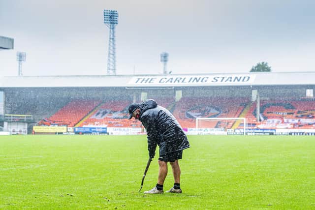 The Dundee United groundsman battles to make the pitch playable before the friendly match between Dundee Utd and Sheffield United at Tannadice was abandoned: Mark Scates / SNS Group