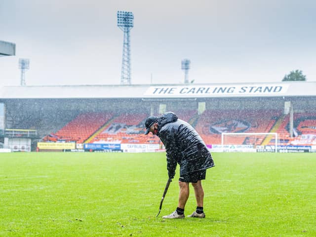 The Dundee United groundsman battles to make the pitch playable before the friendly match between Dundee Utd and Sheffield United at Tannadice was abandoned: Mark Scates / SNS Group