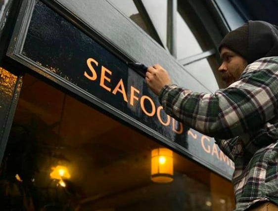 Tatch at work on the windows at Howies in Victoria Steet. He's completing a copper leaf surface gild with a layer of varnish to seal it in. Picture taken by his friend and fellow Edinburgh signwriter Thomas Payne who goes by the name Thomas Paints.
