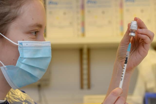 Pharmacist Helen Caley draws the coronavirus vaccine into a syringe