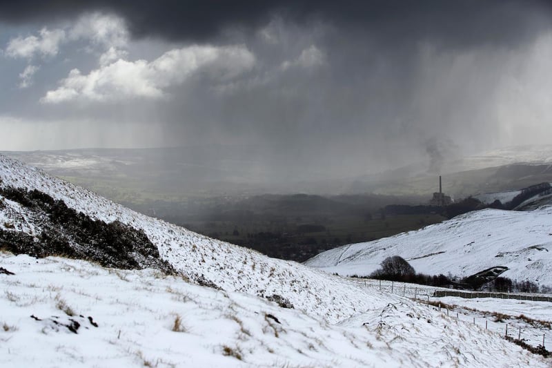 Seen from Mam Tor, snow showers fall over Castleton cement works.
