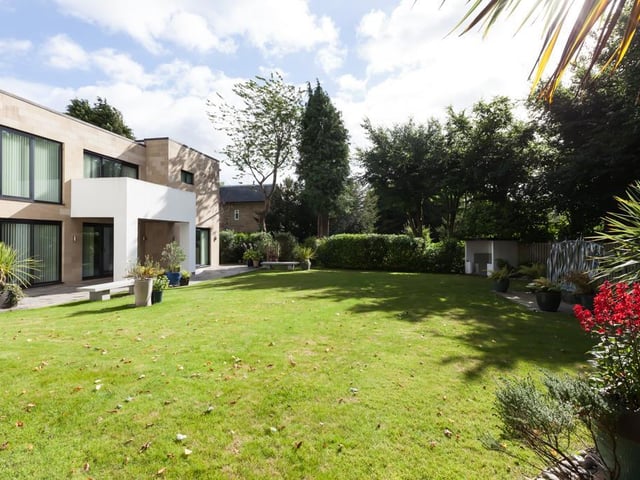 To the front, the garden has a lawn with mature trees, planted shrub borders and a sheltered seating area with fitted timber benches. There’s a stone flagged seating terrace with exterior lighting, as well.