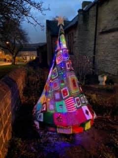 Another one of the knitted Christmas trees illuminated at night.
