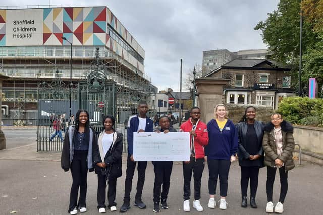Young people from the New Testament Church of God Sheffield pictured with the cheque and Lucy, fundraising officer at The Children’s Hospital Charity.