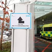 A sign directs patients towards an NHS 111 Coronavirus (COVID-19) Pod. (Photo by ISABEL INFANTES/AFP via Getty Images)