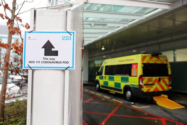 A sign directs patients towards an NHS 111 Coronavirus (COVID-19) Pod. (Photo by ISABEL INFANTES/AFP via Getty Images)