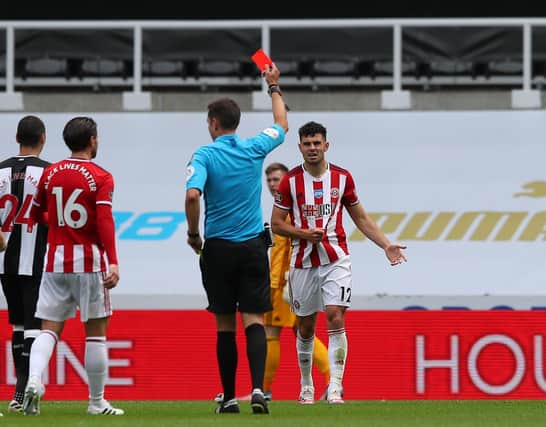 John Egan receives his red card during Sheffield United's defeat at Newcastle, which rules him out of tomorrow's Premier League fixture at Manchester United: Simon Bellis/Sportimage