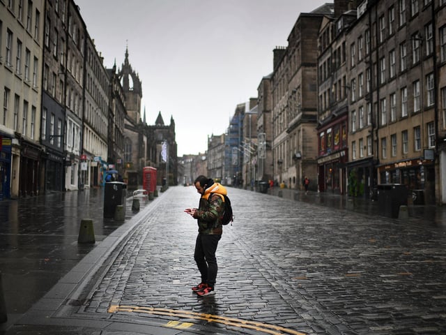 Members of the public walk through a deserted Edinburgh City Centre on January 4, 2021 in Edinburgh, Scotland.