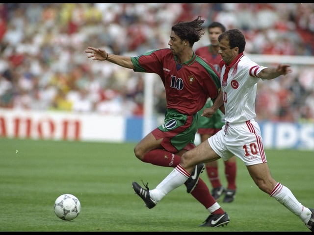 Rui Costa of Portugal is challenged by Oguz Cetin of Turkey in their Group D match.