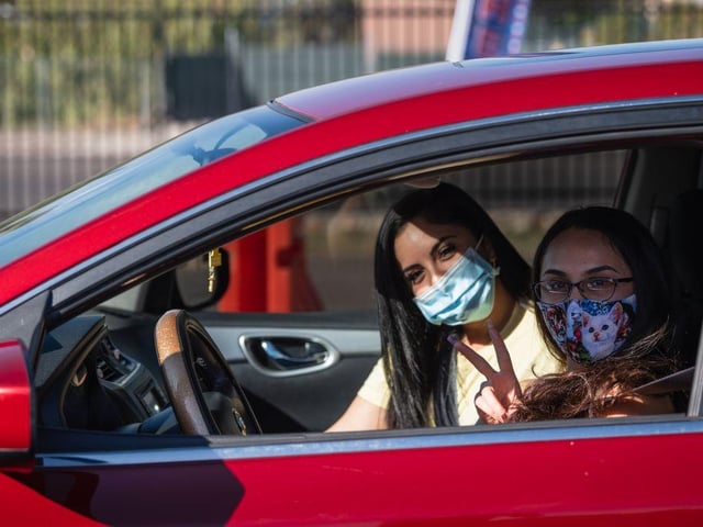 Amanda Franco, 19, and Danielle Franco, 25, pose while waiting to vote by express curbside voting at the El Paso County Coliseum, in El Paso, Texas.