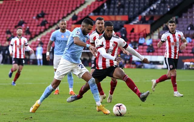 Manchester City's Riyad Mahrez (left) and Sheffield United's Max Lowe battle for the ball: Tim Keeton/PA Wire