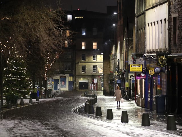 A person walks down a quiet Grassmarket. Photo credit: Andrew Milligan/PA Wire