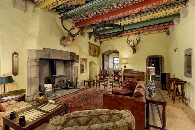 This room has an original stone built fireplace with a log burning stove and an intricately painted ceiling.