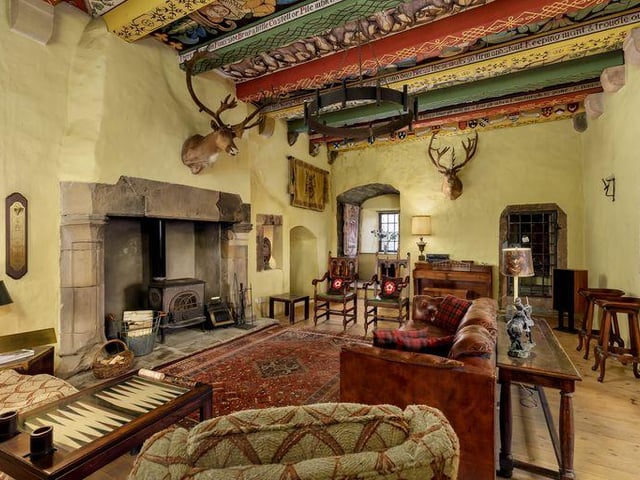 This room has an original stone built fireplace with a log burning stove and an intricately painted ceiling.