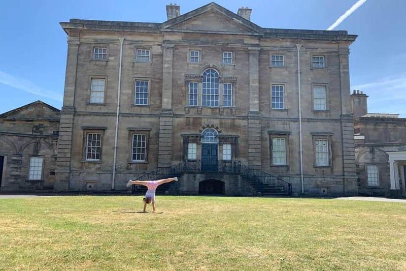A young girl doing a cartwheel in front of Cusworth Hall from Jen Sables.
