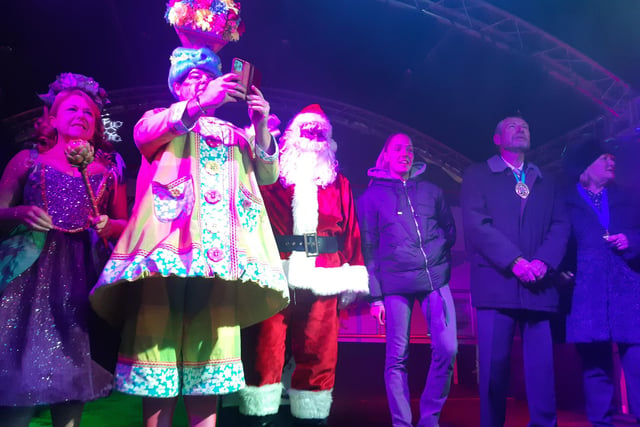 Panto star Damien Williams takes a photo from the stage, with Wendi Peters, Ellie Roebuck, and deputy mayor Colin Ross