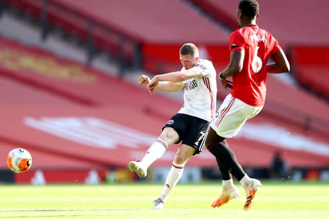 John Lundstram of Sheffield United shoots wide as Paul Pogba of Manchester United looks on during the Premier League match between Manchester United and Sheffield United at Old Trafford on June 24, 2020 in Manchester, England. (Photo by Michael Steele/Getty Images)