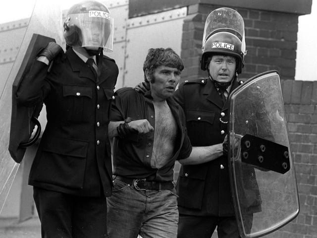 A picket is led away by riot police