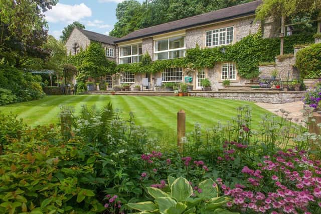 River Cottage has an outdoor terrace with room for a large dining table. The lawned gardens have mature shrubbery borders leading down to the river.