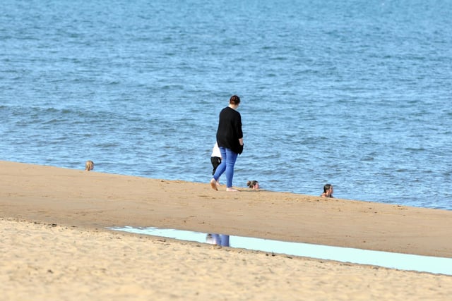 People were pictured walking by the sea as temperatures soar.