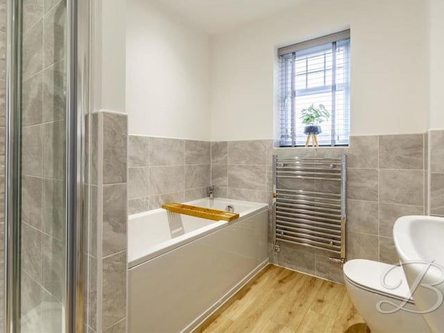 Our tour of the interior is completed by a look at the sparkling family bathroom. Complete with half-wall tiling, it boasts a fitted bath, walk-in shower, low-flush WC, pedestal wash basin, chrome, heated towel-rail and opaque window.