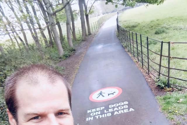 Stocksman Tom Telford pictured next to one of the new signs at Graves Park Sheffield warning dog owners use a lead.