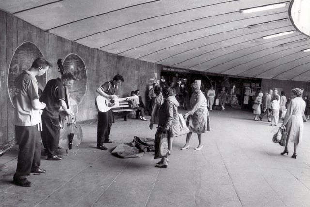 Buskers, the Slingshots, from left, Steve Russell, Johnny Wood and John England, entertaining shoppers, May 16, 1984