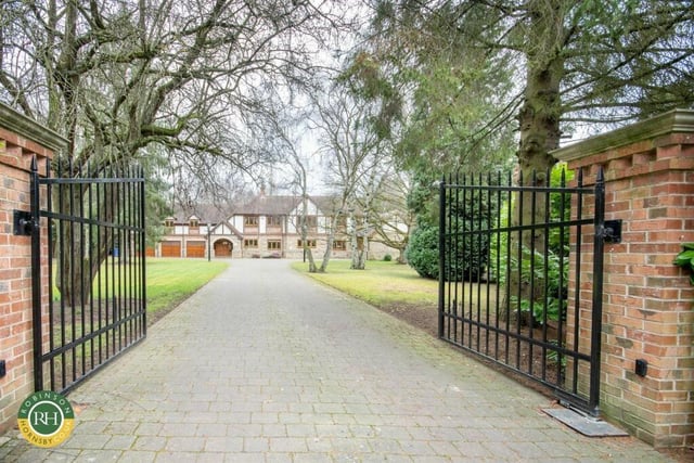 The tree-lined driveway that leads up to the impressive frontage of the house with triple garage.
