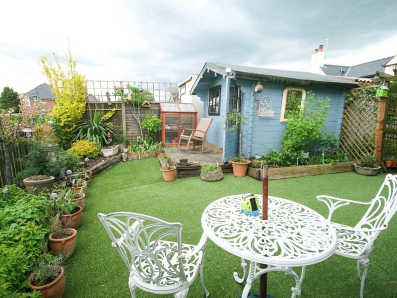 To the rear is a low maintenance garden having artificial turf, flower beds and a timber summerhouse with power.