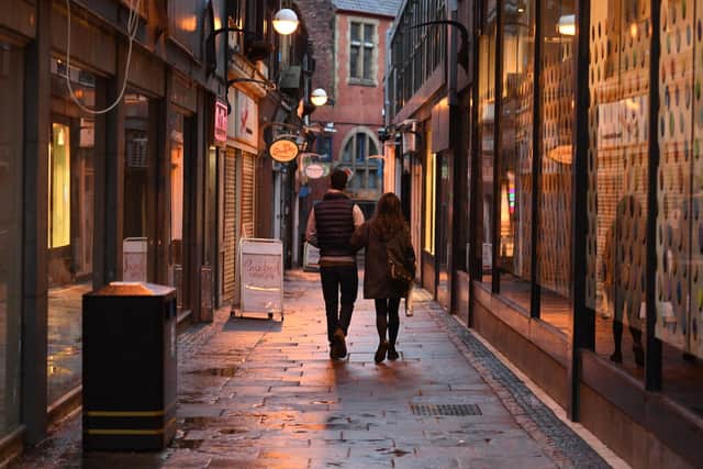A couple walk past closed shops in Sheffield (Photo by Oli SCARFF / AFP) (Photo by OLI SCARFF/AFP via Getty Images)