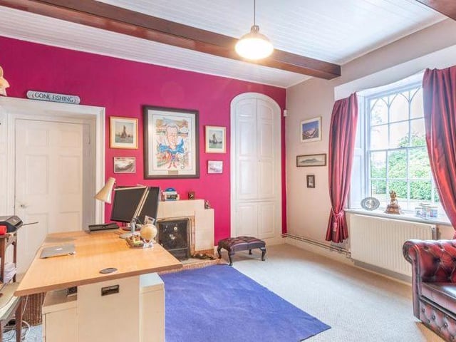 The third of the reception rooms is this traditional study. It also has a feature fireplace.