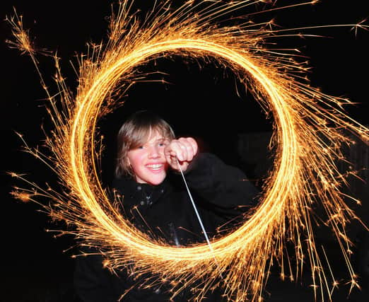 A boy makes light circles with a sparkler during Bonfire Night celebrations. (Photo by Mike Hewitt/Getty Images)