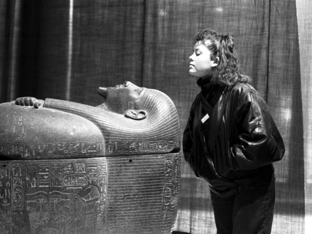 An unidentified female member of staff with the coffin of Psussenes , part of the Gold of the Pharaohs exhibition of ancient Egyptian artifacts at the City Art Gallery in Edinburgh, January 1988. This exhibition attracted an astonishing 447,000 visitors.