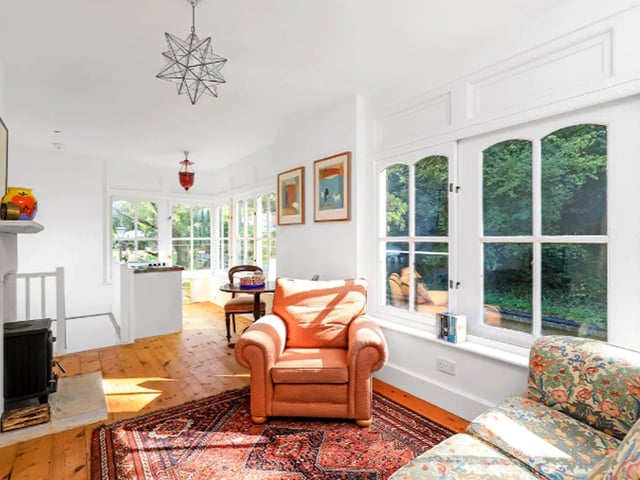 A bright sitting room complete with log burner