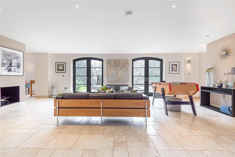 A partition wall separates the spacious lounge area from the garden room, which is bathed in plenty of light from the two sets of double doors leading outside to the garden.
