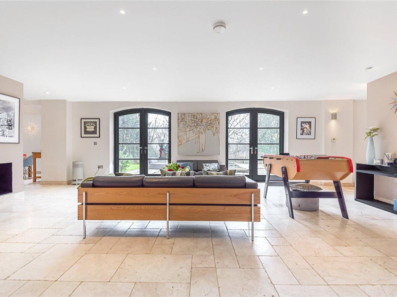 A partition wall separates the spacious lounge area from the garden room, which is bathed in plenty of light from the two sets of double doors leading outside to the garden.