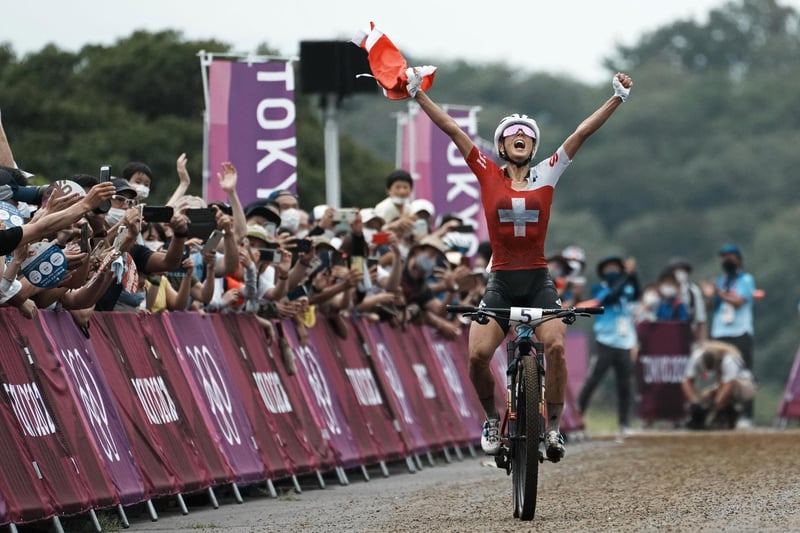 Jolanda Neff of Switzerland celebrates as she approaches the finish line to win the gold medal during the women's cross-country mountain bike competition