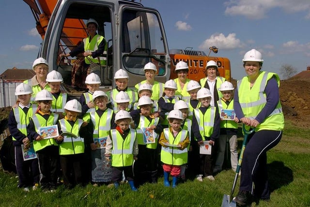 Pictured at Arbourthorne Primary, Sheffield, where the first sod was cut for the new school. Seen is Sheila Haigh, the head teacher, in the earth mover, with pupils, parents and staff.  Digging up the first sod by hand is parent Rachel Toyne (April 2004)