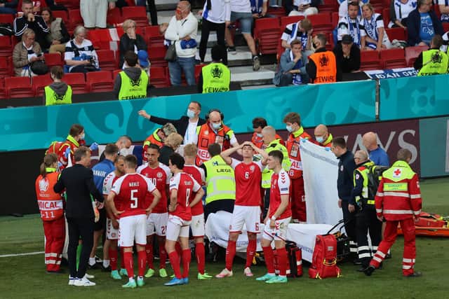 Christian Eriksen (hidden) receives medical treatment during the UEFA Euro 2020 Championship Group B match between Denmark and Finland on June 12, 2021 in Copenhagen, Denmark. (Photo by Wolfgang Rattay - Pool/Getty Images)