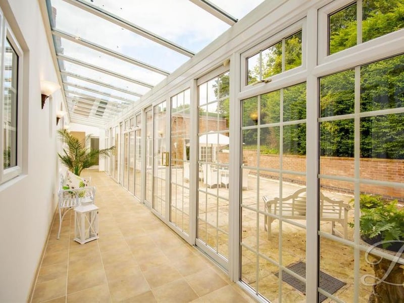 We're making our way outside now on our tour of the Manor House. And what a way to do it via this conservatory-style passageway.