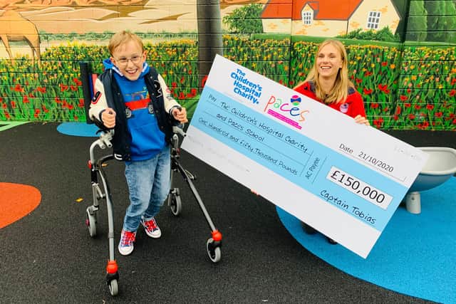 Tobias presents the cheque to Ruth, headteacher at Paces School