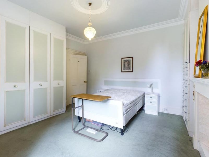 Dining Room - Currently in use as a ground floor bedroom - Timber framed single glazed window to the rear elevation, ceiling coving, a range of fitted wardrobes and draws to two walls, inset wash basin with vanity surround, feature fire surround with tiled inset; power point.
