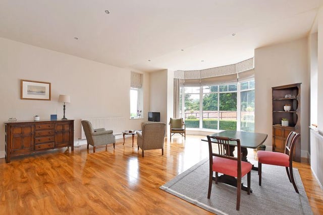 The open-plan living area has mahogany-style laminate flooring that extends up to the bay window.
