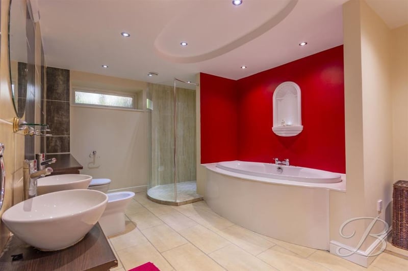 The impressive en-suite to the main bedroom. It boasts two wash hand basins, a vanity unit, a low-flush WC, a bidet, bath, walk-in shower and opaque window.
