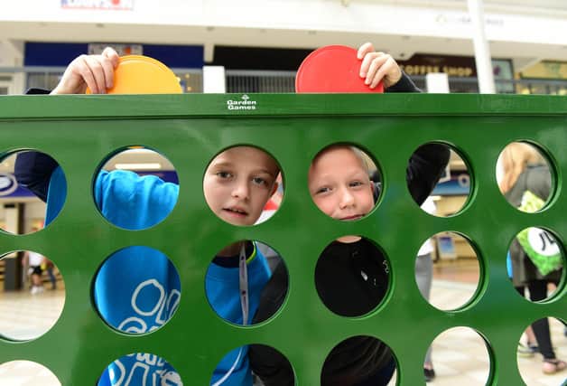 Harry Ainsley, 11, and Jack Warrington, eight, try the giant connect 4 game during the One Great Day event charity event in Hartlepool's Middleton Grange Shopping Centre.