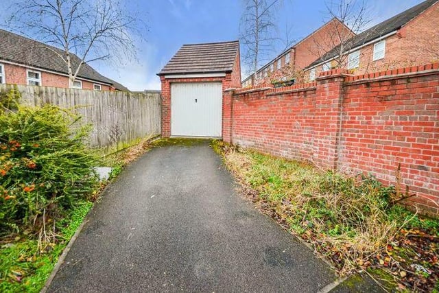 Our final photo of the property shows the driveway to a detached garage, which is part of the garden.