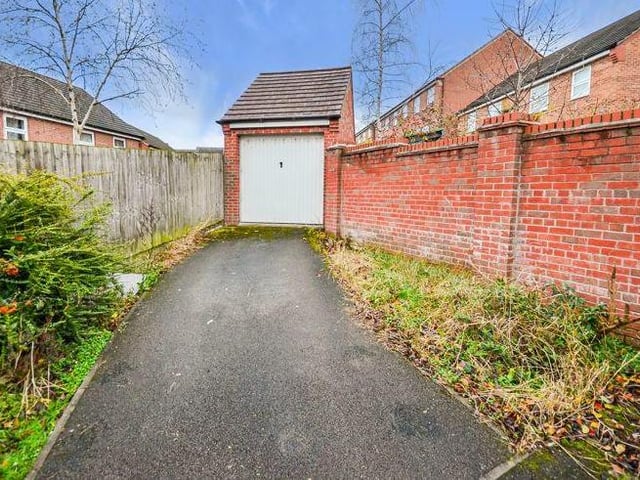 Our final photo of the property shows the driveway to a detached garage, which is part of the garden.