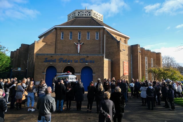 Mourners gather outside the church.