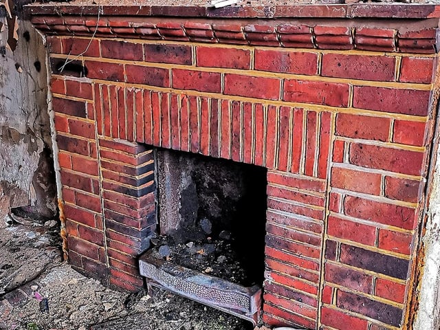 A brick fireplace remains inside.