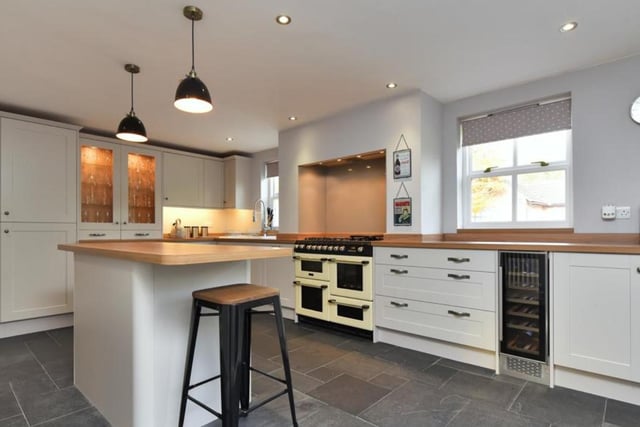 The bespoke kitchen has and island and display cupboards.